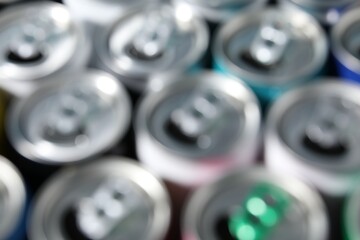Many aluminium cans of beverage as background, blurred view