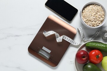 Electronic kitchen scale, measuring tape, smartphone and products on white marble table, flat lay. Diet