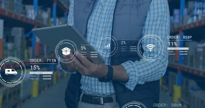 In warehouse, businessman using tablet with animation of data analytics and graphs