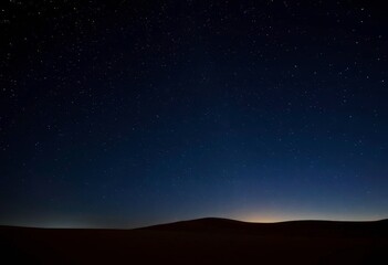 Fototapeta premium Twinkling star particles shimmer across a dark desert night sky on a simple background, abstract, astrophysics
