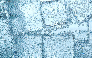 Refreshing soda water with ice cubes against white background, closeup