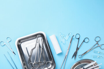 Different surgical tools on light blue background, flat lay. Space for text