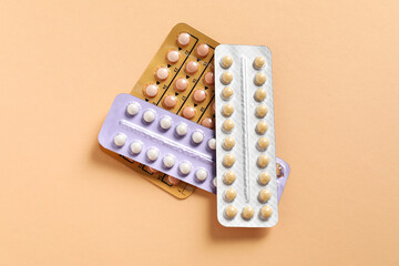 Blisters of contraceptive pills on beige background, top view