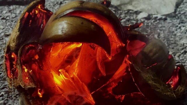 Fire burning coconut husks with flames and smoke for burning charcoal or mark natural fuel or preparing traditional cooking and outdoor activities 