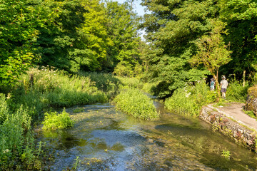 River Bradford and couple wearing hats walking on Limestone Way, Derbyshire, UK