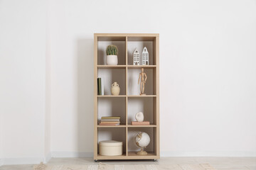 Shelving unit with different home decor near white wall indoors