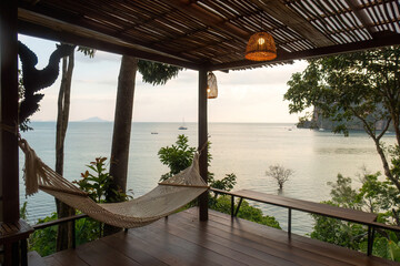 Hammock on wooden terrace overlooking sea, relaxation