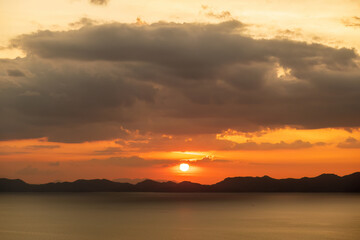 Dramatic sunset over water and mountains, nature background