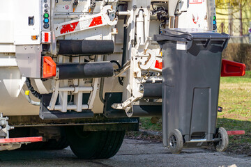 presentation of a modern electric garbage truck with a modern working mechanism. Garbage truck with a plastic garbage bin during work. garbage collection.
