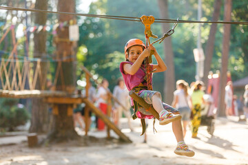happy little girl in a rope park on the wood background
