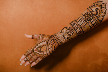 Close-up of intricate henna designs on hands, with palms facing up, showcasing beautiful