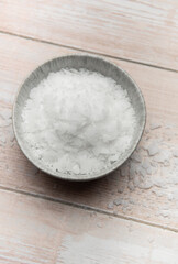 Magnesium flakes in a bowl on wooden table