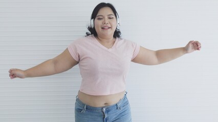 Fat Asian woman listening to music and dancing