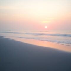 Soft-focus sunrise over calm ocean beach.