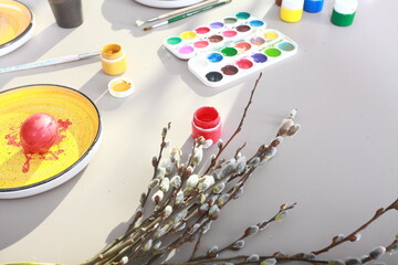 children paint eggs for easter celebration at home on table