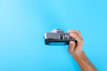 Photographer with vintage camera on light blue background, above view. Space for text