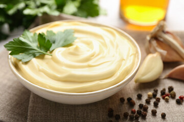 Delicious mayonnaise sauce with parsley in bowl on table, closeup