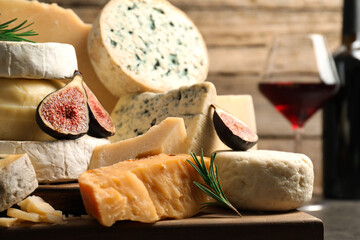 Different types of cheese, figs and rosemary on table, closeup