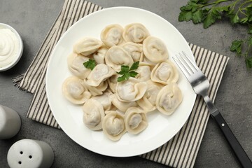 Delicious dumplings served on grey table, flat lay