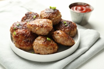Delicious patties with green onions and ketchup on white table, closeup