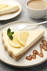 Pieces of delicious lemon cheesecake served on grey textured table, closeup