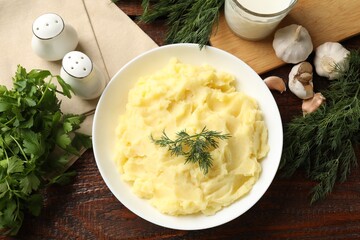 Delicious mashed potato with dill served on wooden table, flat lay