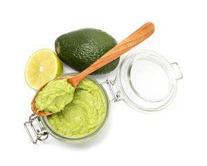 Tasty avocado dip in glass jar, lime and spoon isolated on white, top view