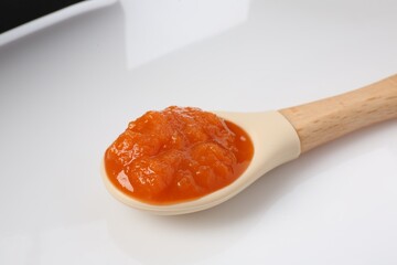 Baby food. Tasty puree in spoon isolated on white