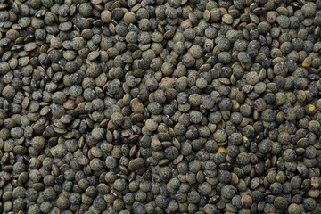 Raw green lentils as background, closeup view
