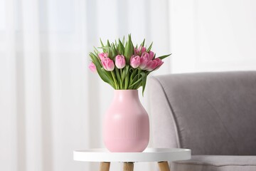 Bouquet of beautiful tulips in vase on table indoors