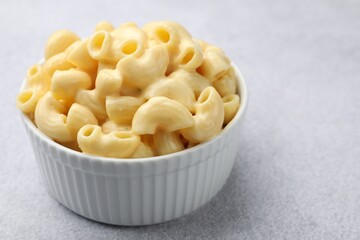 Delicious pasta with cheese sauce in bowl on grey table, closeup. Space for text