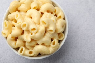 Delicious pasta with cheese sauce in bowl on grey table, top view