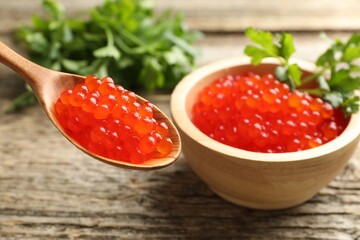 Red caviar and parsley on wooden table, closeup
