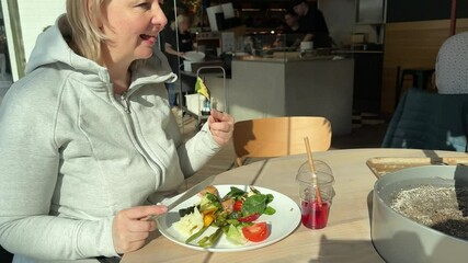 plump adult woman on diet eats healthy food european woman in grey tracksuit