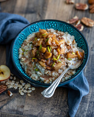 Cropped Angled View of an Apple Pecan Oatmeal with Pistachios on a Wooden Table