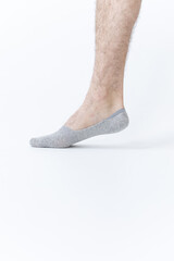 Male leg in short gray sock on white background