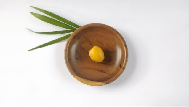 A fresh young dates or rutob dates or ruthob dates on a wooden plate with a white background.