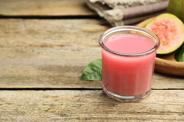 Refreshing guava juice and fresh fruits on wooden table, closeup. Space for text