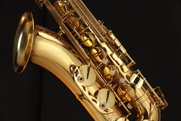 Jazz. One beautiful saxophone on black background, closeup