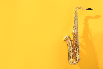 Golden saxophone on yellow background. Space for text
