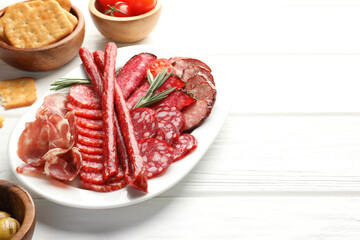 Different smoked sausages slices served on white wooden table, closeup. Space for text
