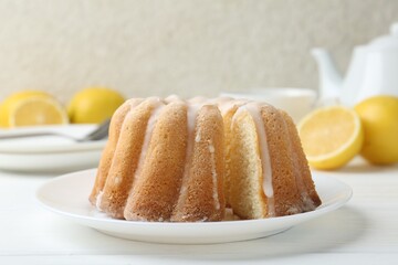 Delicious lemon cake with glaze on white wooden table, closeup