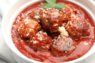 Delicious meatballs with tomato sauce, parmesan cheese and parsley in bowl, closeup