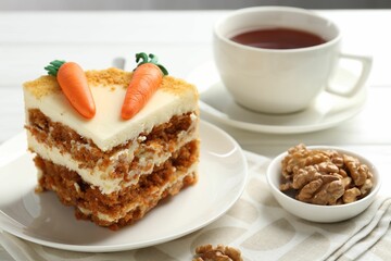 Piece of delicious homemade carrot cake served on white wooden table, closeup