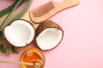 Hair treatment. Fresh coconut, honey, comb and aloe leaves on pink background, flat lay. Space for text
