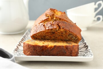Cut homemade carrot cake with nuts on light grey table, closeup