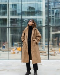 Fototapeta premium Fashionable Woman in Brown Coat Posing Stylishly Outdoors