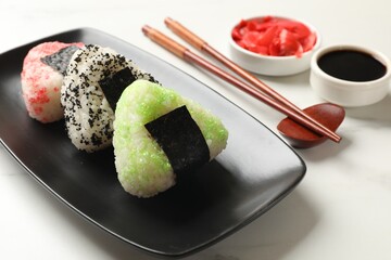 Tasty tobiko onigiri (Japanese rice balls) served on white table, closeup