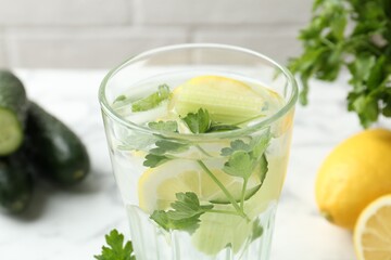 Healthy drink with parsley, cucumbers and lemons on table, closeup