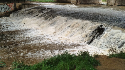 Crecida de río por abundantes lluvias un día lluvioso en Burgos, España